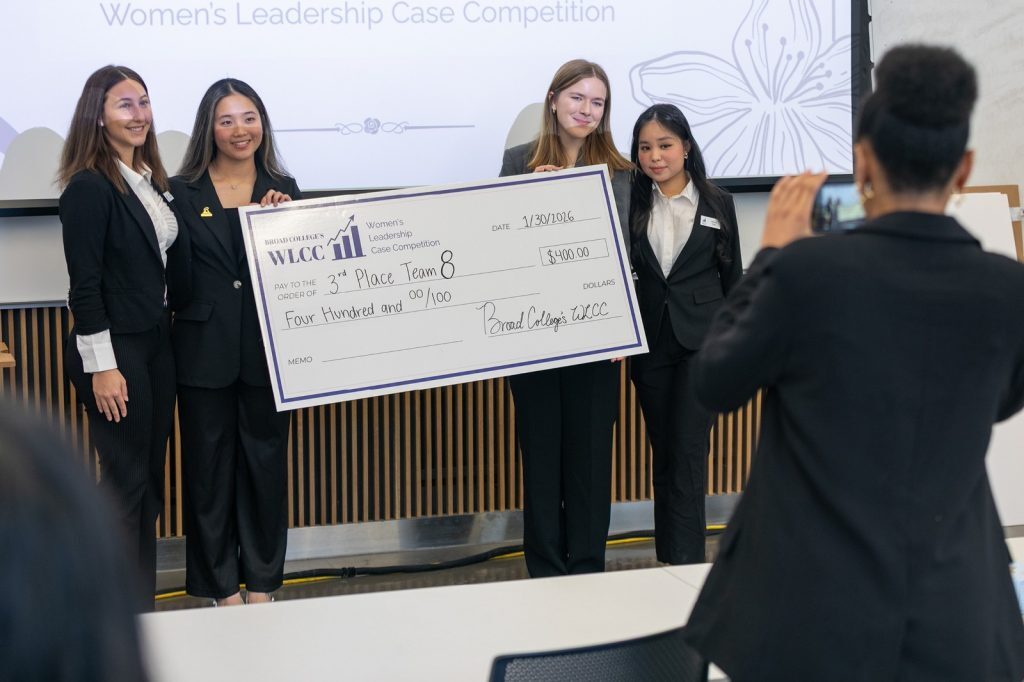 3rd place team holding oversized check