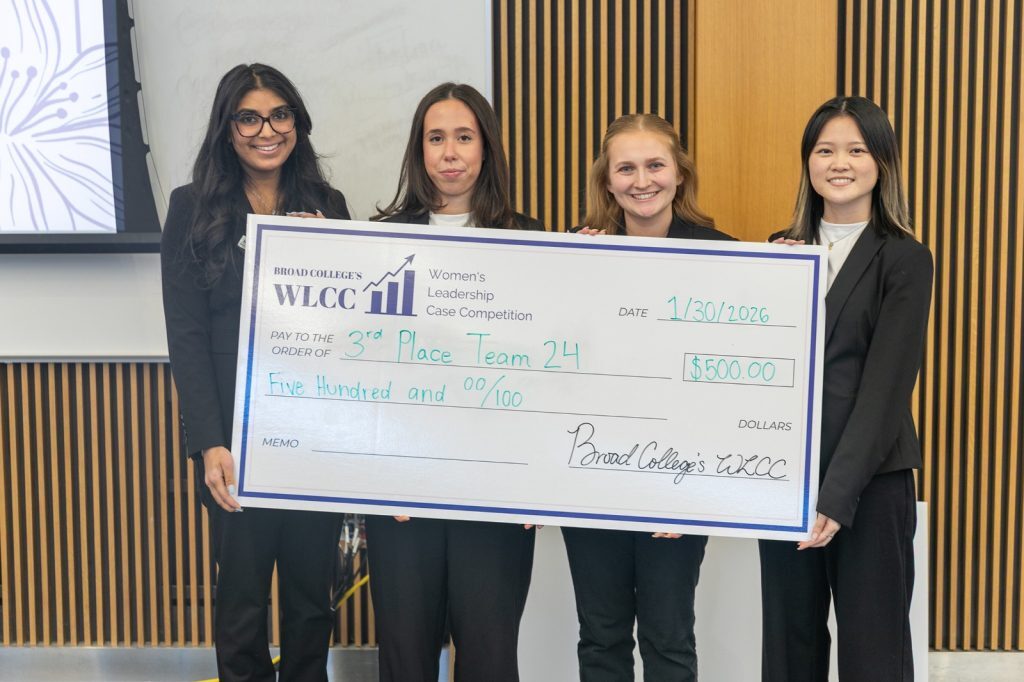 Third place winners holding oversized check