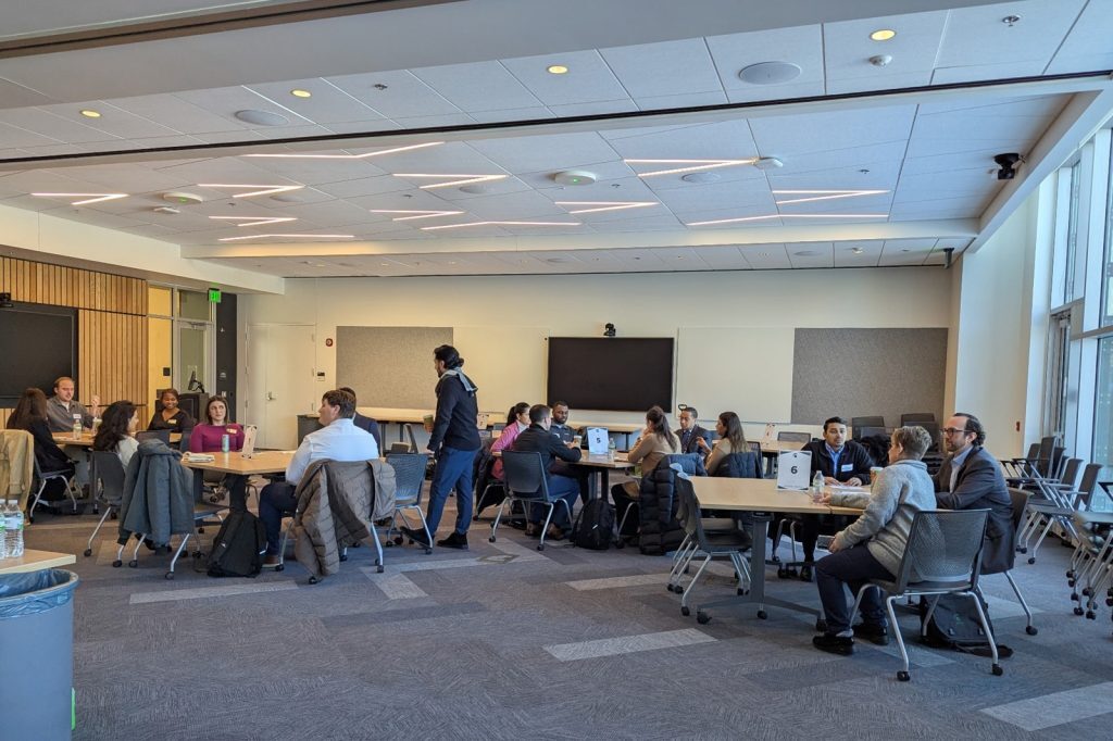 Participants seated at grouped tables working together