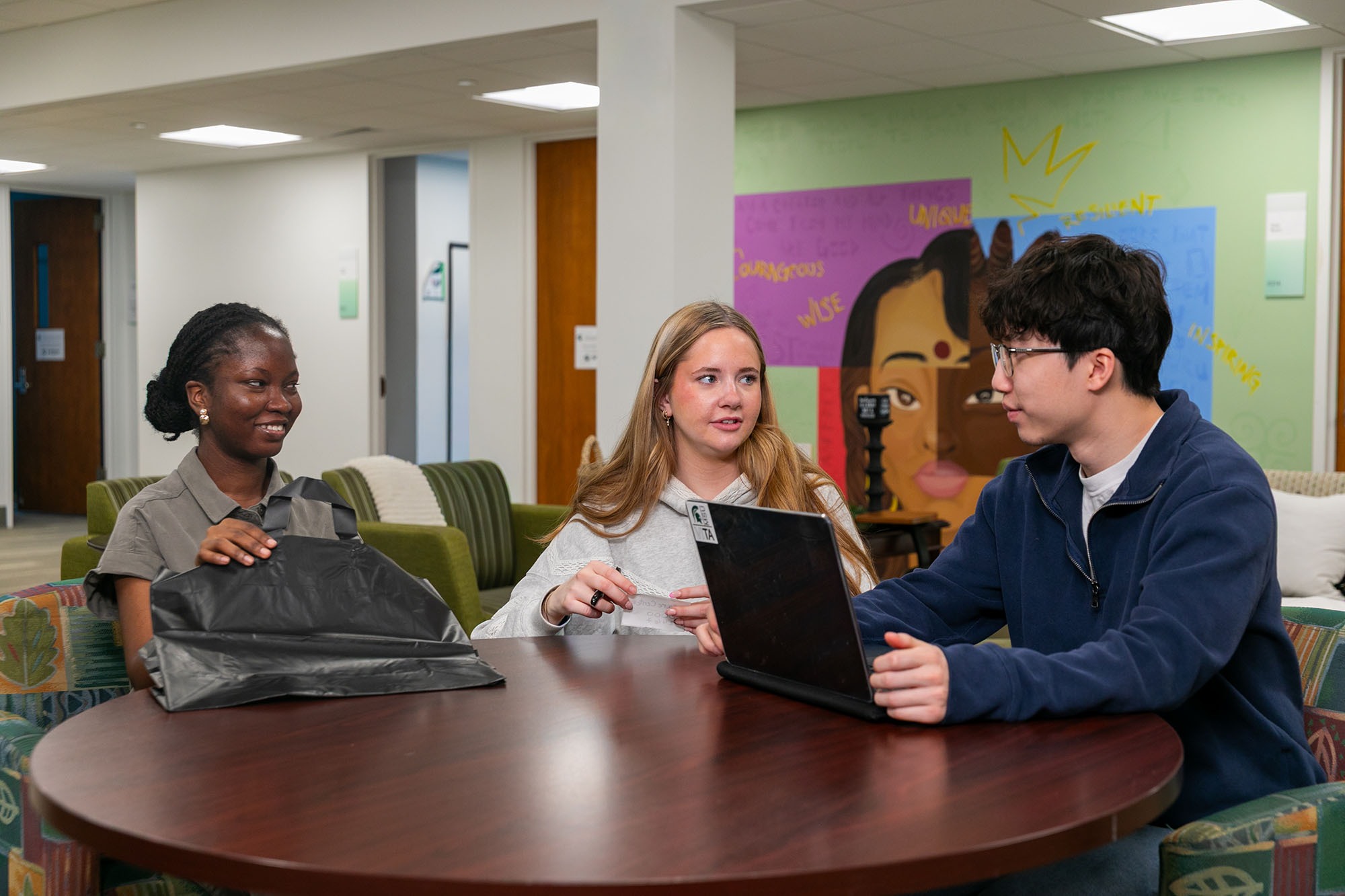 Student care center volunteers meeting at a table.