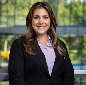 headshot of a smiling woman with brown hair wearing business attire