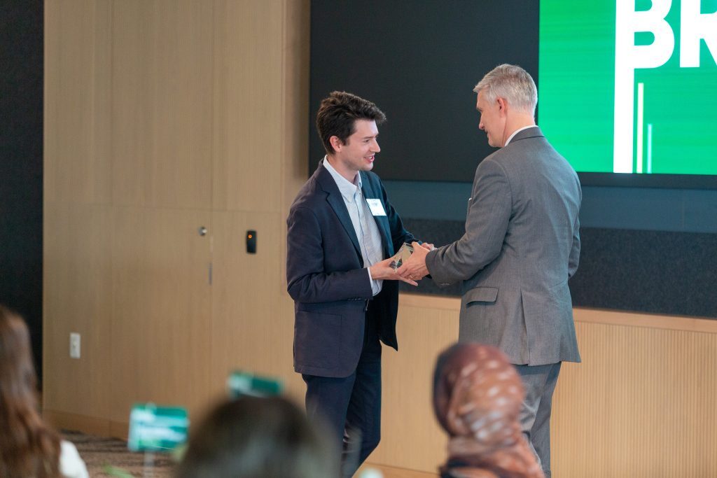 A presenter hands an award to a recipient on stage during the Celebrate Broad recognition ceremony.