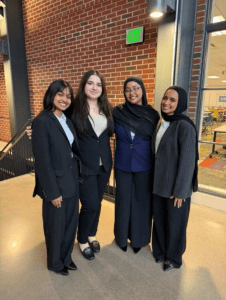 4 people standing together in workwear smiling 