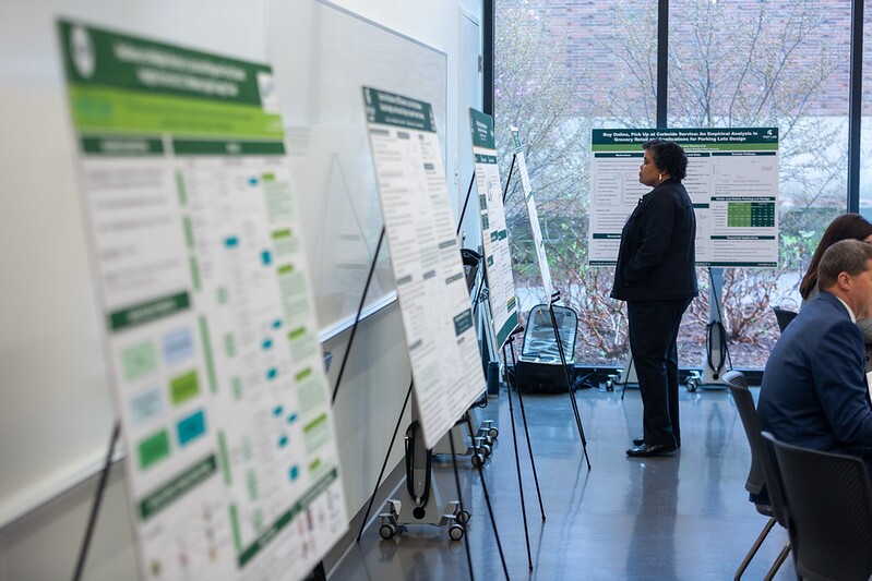 A participant looking at one of the submitted informational posters displayed at the Symposium.