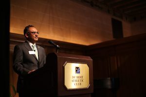 Sanjay Gupta stands a podium in the Detroit Athletic Club.
