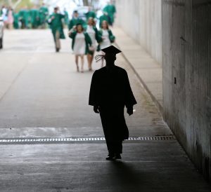 The silhouette of a Spartan graduate as they walk out of the stadium into the sunlight