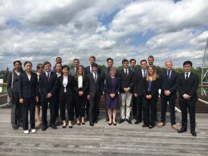The education abroad group stands for a picture with the professor who leads the program in their formal attire