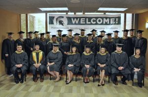 MS Management, Strategy, and Leadership graduates pose for a class photo in front of a "Welcome! Management, Strategy, and Leadership students" banner