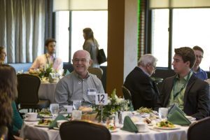 Broad donors sit at a table with student scholarship recipients they impacted.