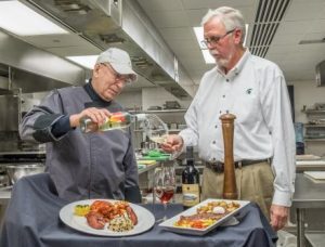 Allan Sherwin pours Carl Borchgrevink a glass of wine.
