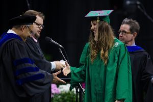 Eli Broad College of Business Dean Sanjay Gupta (left) expresses astonishment at Nicole Niemiec's Sparty mascot footwear at college commencement ceremonies in May. Photo by Matthew Mitchell
