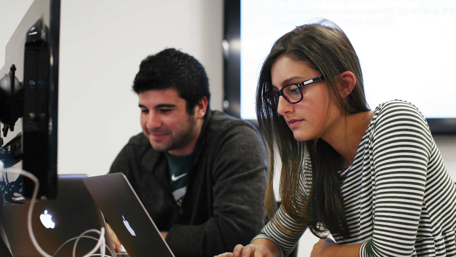 Undergraduate students in the Broad College of Business working in a lab space on laptops.