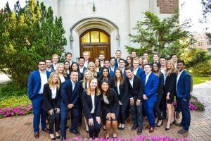 Students dress in their professional attire and stand in front of MSU's Beaumont Tower
