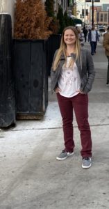 Anna Foster (B.A. Supply Chain Management ’10) dressed casually standing out side on a city sidewalk.