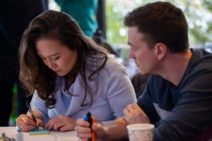 Two MBA students working together, writing notes during the 2020 Extreme Green vent.