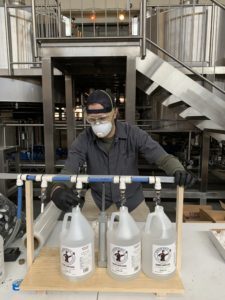 An Atwater employee filling hand sanitizer gallons.