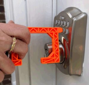 Someone using the Spartan-designed No Touch Tool to press a button and open a door.