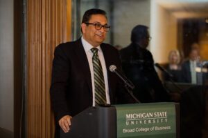 Manoj Saxena, (MBA ’91), executive chairman of CognitiveScale speaking at a podium for a Michigan State University event.